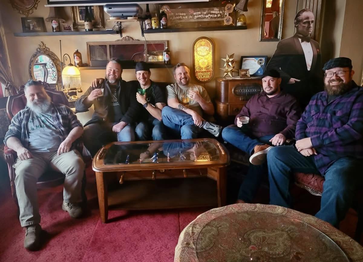 Six guys sit in a bar lounge